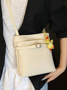 Borsa a secchiello beige minimalista in pelle con ciondolo a forma di papera