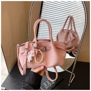 Detailed macro of pink lychee leather handbag with silver lock and pearl charm