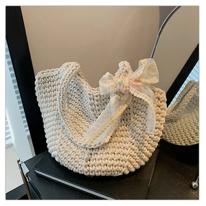 Detail of hand-woven tote bag showing thick knit texture and delicate lace floral accents