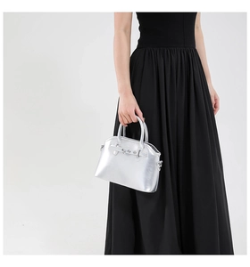 Silver metallic trapezoid handbag shown on model for size and high-shine texture detail