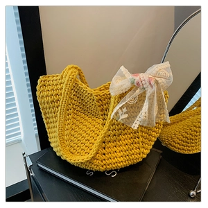 Close-up of yellow woven tote bag featuring a decorative white lace floral bow detail