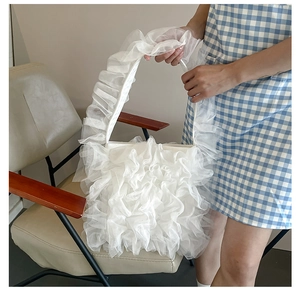 Detail shot of white layered ruffle shoulder bag featuring lightweight pleated organza fabric