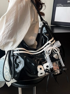 Sac hobo en cuir verni noir brillant avec rayures blanches et écusson du numéro 88