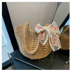 Detail of hand-woven beige tote bag featuring pink lace floral bow and texture