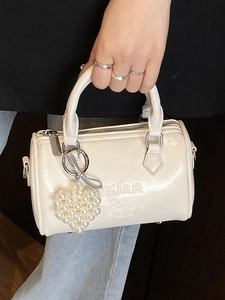 Elegante borsa a bauletto in pelle crema con scritte a rilievo e ciondolo cuore di perle