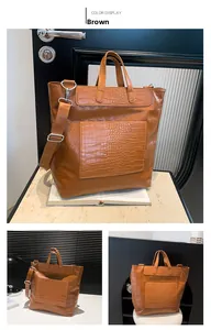 Detail view of brown PU leather tote with embossed skull pattern and crocodile texture