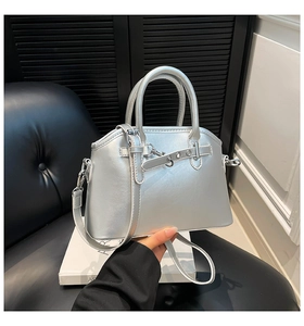 Detail of silver shell bag with metallic oil wax finish and decorative buckle strap