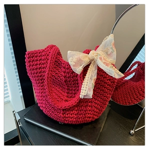 Detail of red woven tote bag with a floral lace bow accent and handmade texture