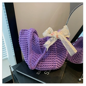 Detail of purple knitted tote bag with decorative lace bow and floral embroidery