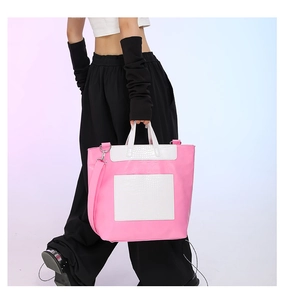 Detail view of pink and white crocodile pattern tote bag shown with model for scale