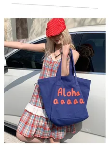 Close-up of a large navy canvas tote bag with orange Aloha typography for summer