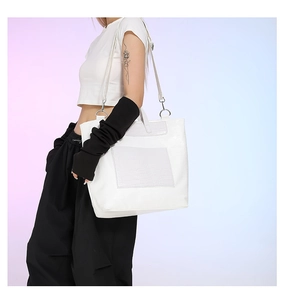 Detailed view of white crocodile pattern tote bag with adjustable shoulder strap and handles