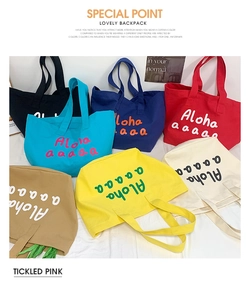 Detail view of colorful canvas tote bags with Aloha print in vibrant summer shades