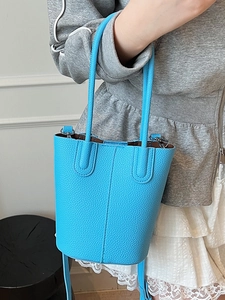 Sky blue litchi grain bucket bag with elegant leather handles and minimalist design