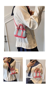 Detail of mini denim crossbody bag with pink leather trim and detachable shoulder strap