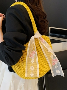 Handwoven yellow crochet tote bag with white lace ribbon and pink floral embroidery detail