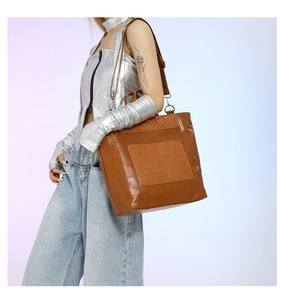 Brown crocodile texture tote bag with skull pattern shown on a model for size perspective