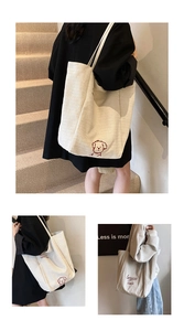 Detail of off-white canvas tote bag featuring red dog embroidery and minimalist lettering