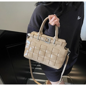 Dettaglio borsa a secchiello beige intrecciata con fibbia in argento e tracolla regolabile