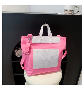 Detail of pink tote bag with skull texture and white croc-patterned front pocket