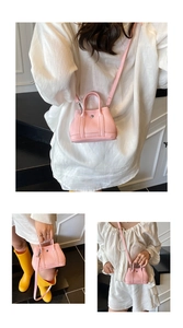Detail view of pink mini crossbody bag with lychee texture and silver round buckle accent