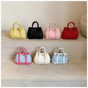 Detailed row of mini leather and canvas tote bags showing various colors and textures
