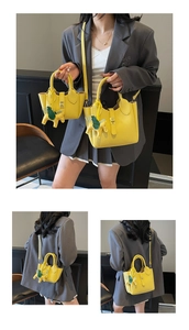 Vue détaillée du sac seau jaune en cuir grainé avec breloque cheval et fermoir métallique