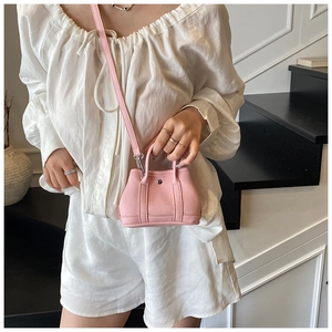 Pink lychee texture mini crossbody bag with top handles and a detachable strap