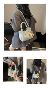 Détail du sac seau bleu clair en cuir grainé avec breloque cheval et fermoir doré chic