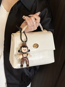 Borsa a mano minimalista crema in pelle cerata con chiusura dorata e ciondolo a pupazzo