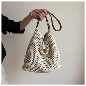 Close-up of beige woven tote bag with open-knit texture and brown leather strap