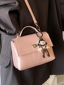 Borsa a tracolla rosa in ecopelle con chiusura a rotazione e ciondolo di perle