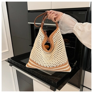 Detail of hollow crochet tote bag with brown leather straps and woven mesh design