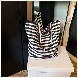 Close-up of navy blue and white striped canvas tote bag with red character embroidery