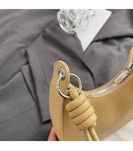 Dettaglio della borsa a mezzaluna in pelle litchi beige con finiture in argento lucido