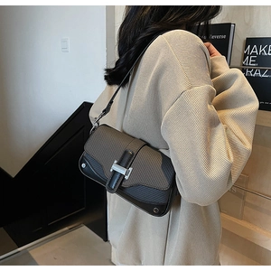 Close-up of contrast stitching shoulder bag featuring silver H-shaped buckle detail