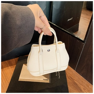 Close-up of creamy white lychee grain leather mini tote bag with silver metal buckle