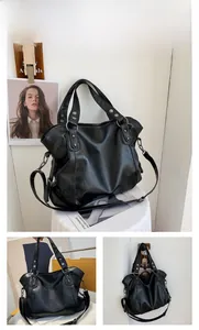 Detail view of large black tote bag featuring reinforced handles and metal rivet accents