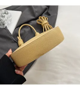 Dettagli del fondo piatto e delle cuciture della borsa in pelle gialla testurizzata