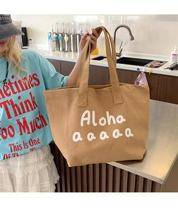 Detail of a khaki canvas tote bag with white Aloha lettering in a lifestyle kitchen setting
