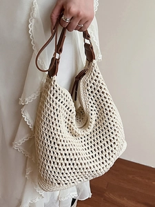Minimalist woven straw tote bag with brown leather handles and spacious interior