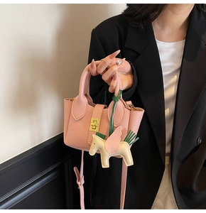 Sac seau rose en cuir grainé avec fermoir tournant et détail de charme de cheval