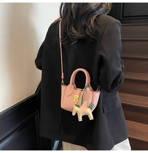 Détails du sac seau rose en cuir grainé avec un pendentif pégase et boucle dorée