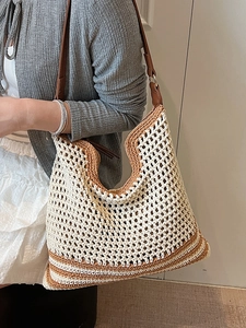 Minimalist woven crochet tote bag with brown leather straps and striped bottom