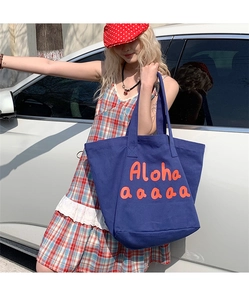Detail of navy canvas tote bag with orange Aloha letter print and wide straps