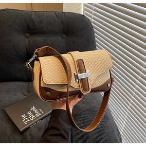 Detail of woven straw and brown leather shoulder bag with silver metallic square buckle