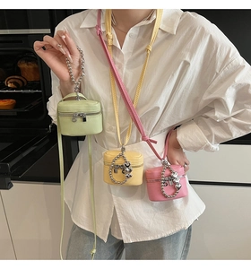 Detailed view of mini macaron crossbody bags in mint green, yellow, and pink colors