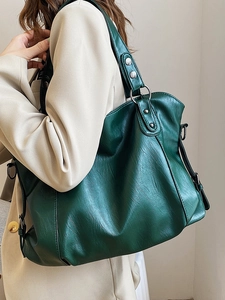 Minimalist large vintage green faux leather tote bag with rivets shown on a model shoulder