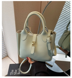 Detail showing the light green pebble grain leather texture and gold metal turn-lock