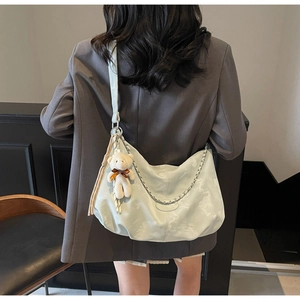 Détail du sac croissant vert menthe avec chaîne argentée et breloque ours peluche